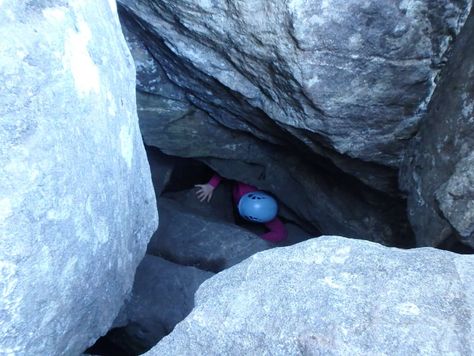 Elever som klatrer gjennom grotte