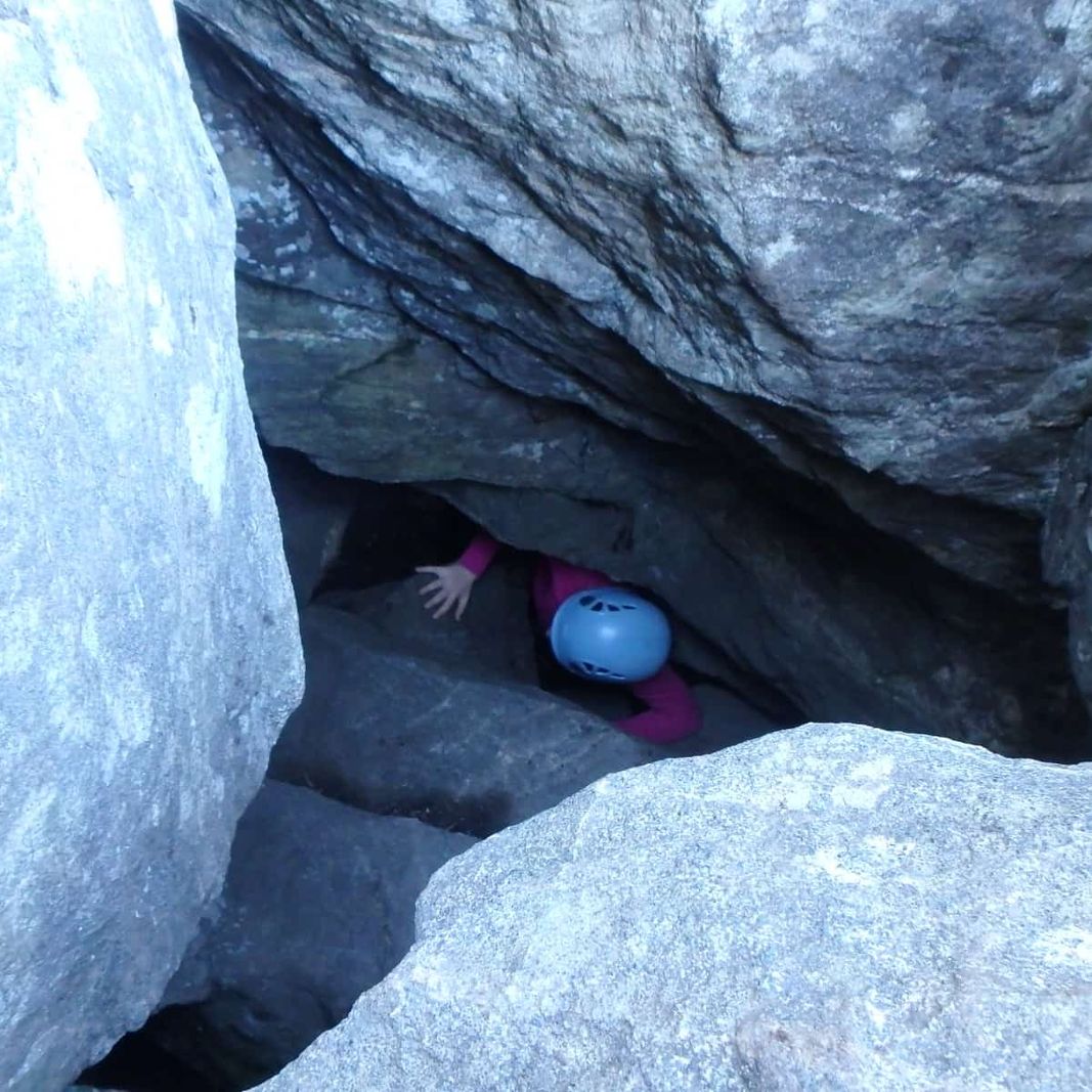 Elever som klatrer gjennom grotte