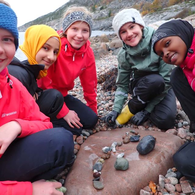 Elever som har samlet steiner på stranda